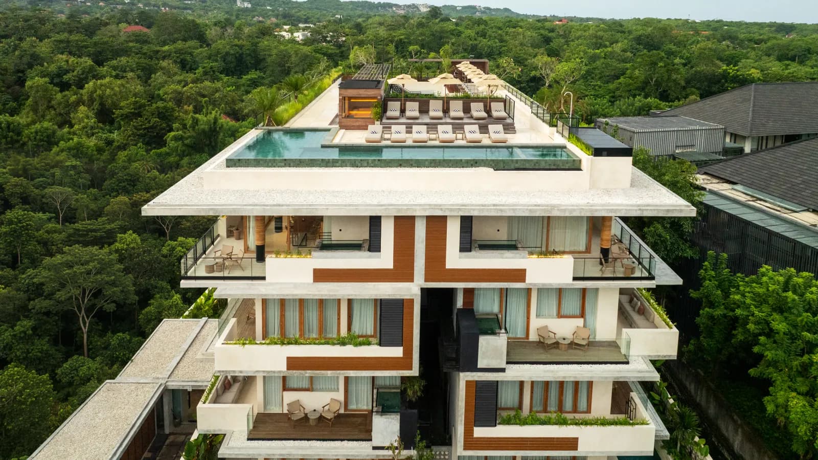 Aerial view of the completed Lifestyle Residence Uluwatu, its rooftop pool and the forest around it
