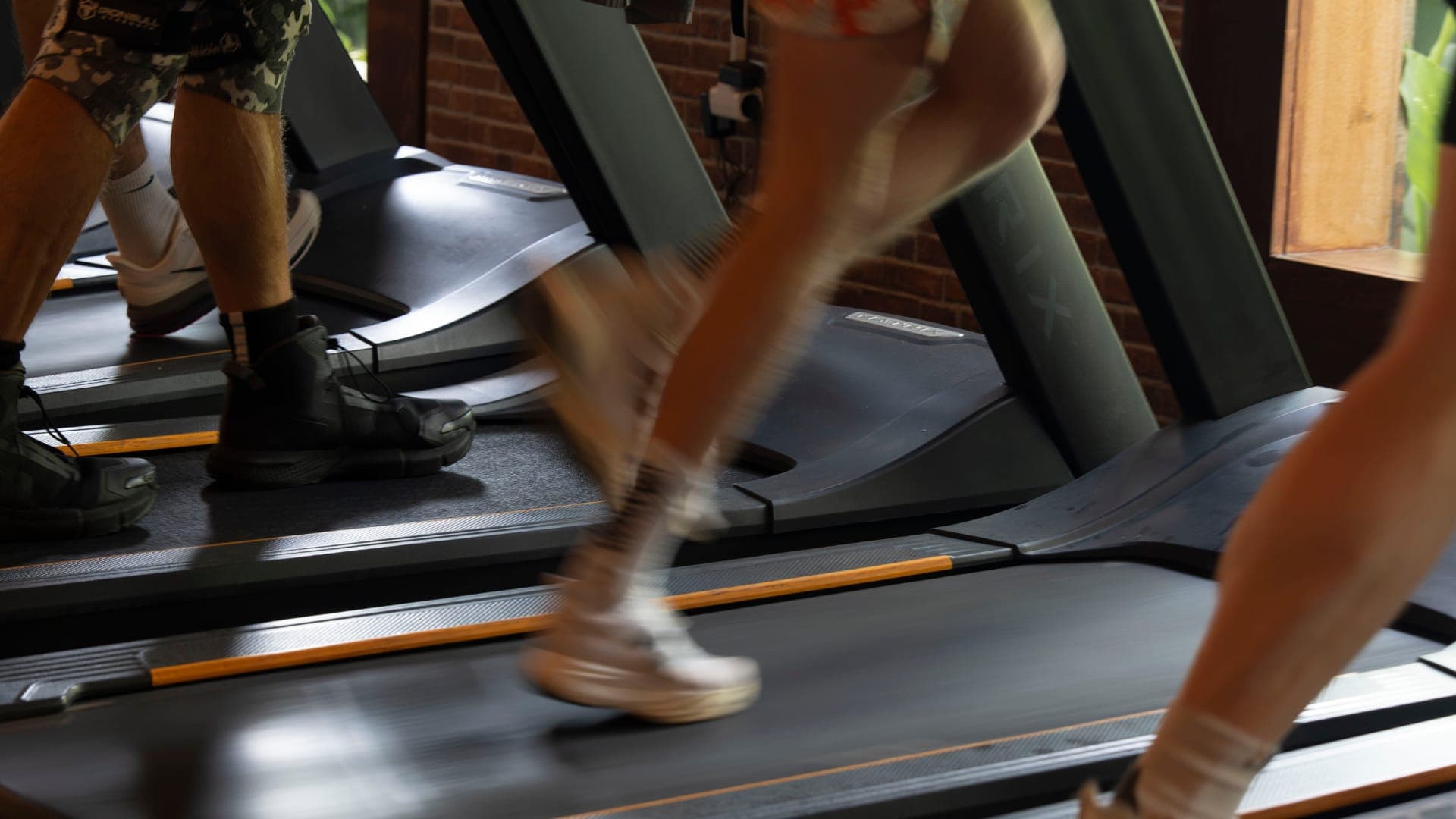 Body Factory members running together on side-by-side treadmills, group cardio in motion