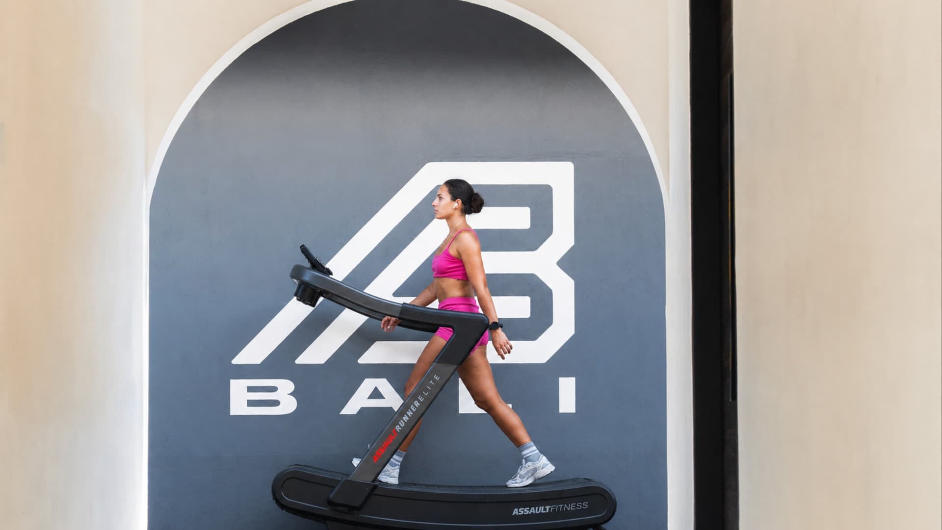 Body Factory training, a runner on a curved treadmill in front of the BODY FACTORY BALI brand wall